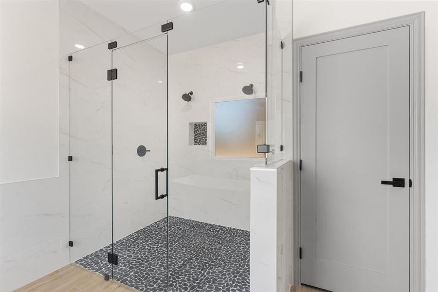 Full bath with a marble finish shower and wood finished floors