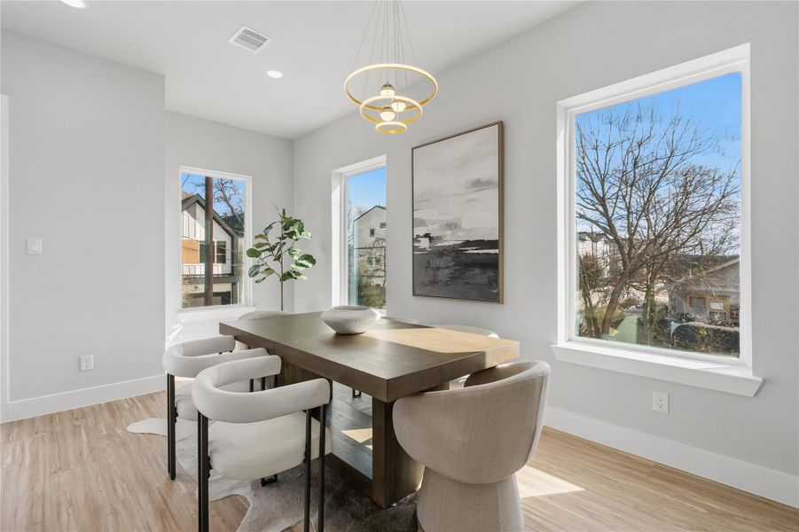 Sunlit dining space with large windows and contemporary statement lighting.Perfectly positioned for everyday meals and effortless entertaining.