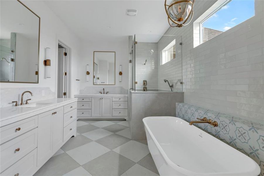 Full bath featuring two vanities, a soaking tub, a walk in shower, light flooring, and tile walls