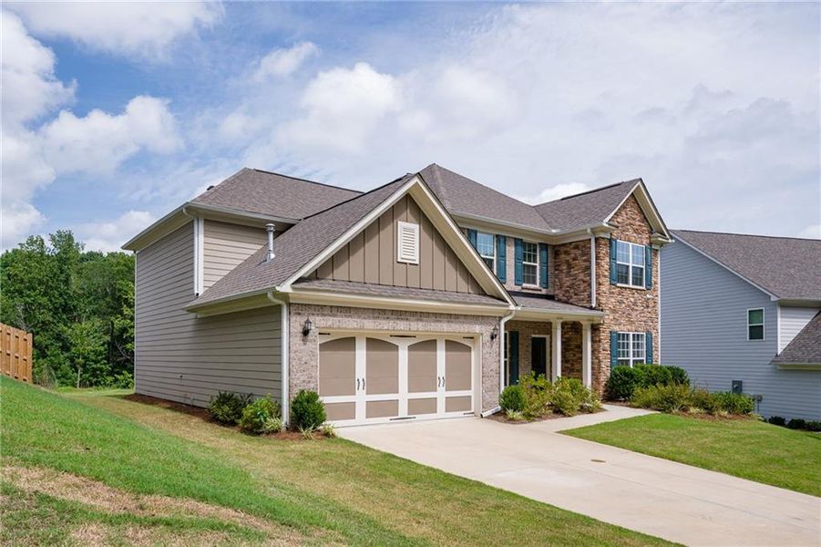 Front exterior of a new home in Sierra Creek, Hoschton, GA, highlighting curb appeal (Image 1). Front exterior of a new home in Sierra Creek, Hoschton, GA, highlighting curb appeal (Image 1).
