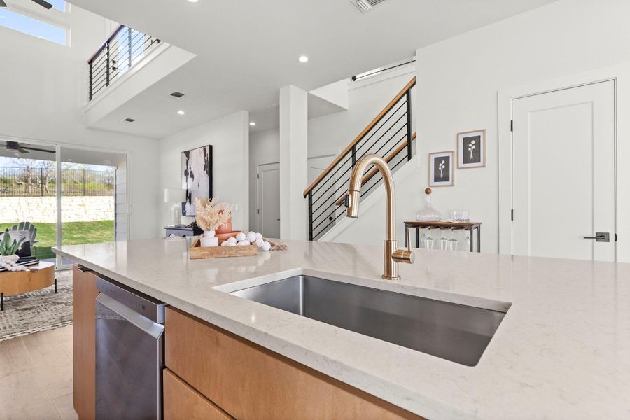 Kitchen featuring light stone counters, dishwasher, recessed lighting, open floor plan, and light wood-style flooring