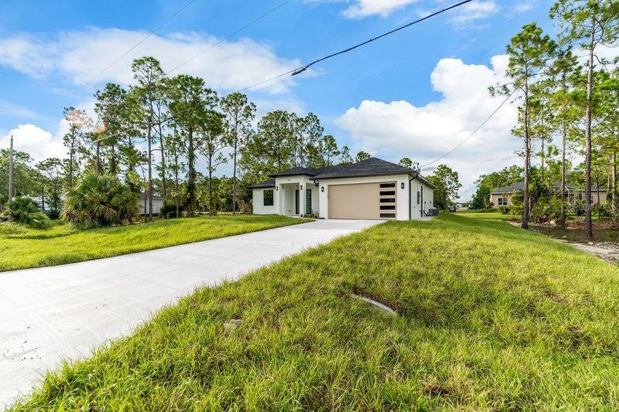 Front exterior of a new home in , Lehigh Acres, FL, highlighting curb appeal (Image 24).