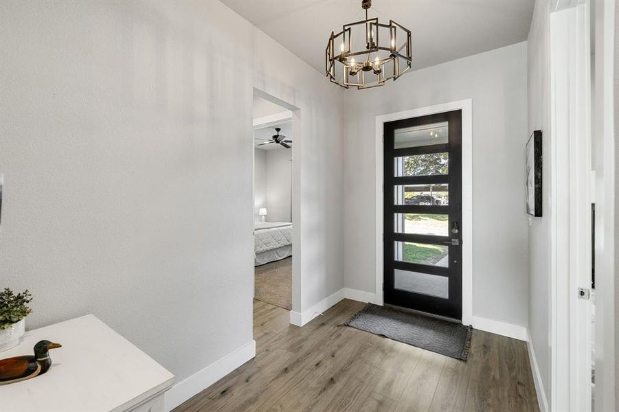 Foyer entrance featuring wood finished floors, a chandelier, and ceiling fan