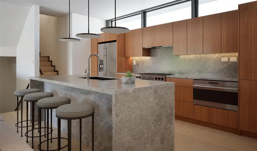 Kitchen with decorative backsplash, a kitchen bar, light wood-style flooring, and modern cabinets Kitchen with decorative backsplash, a kitchen bar, light wood-style flooring, and modern cabinets