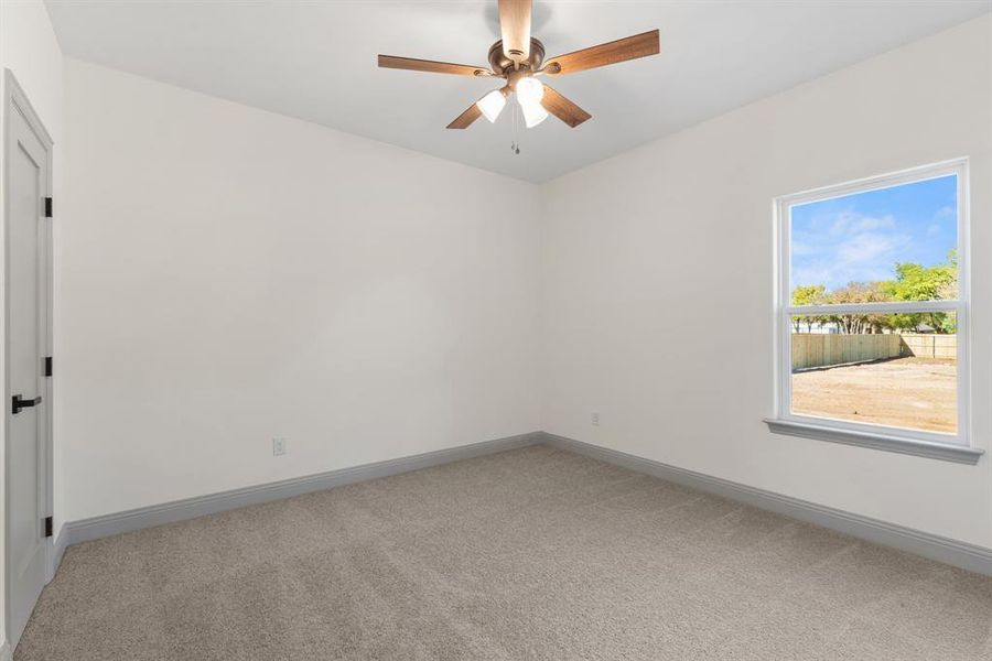Spare room featuring light carpet and a ceiling fan