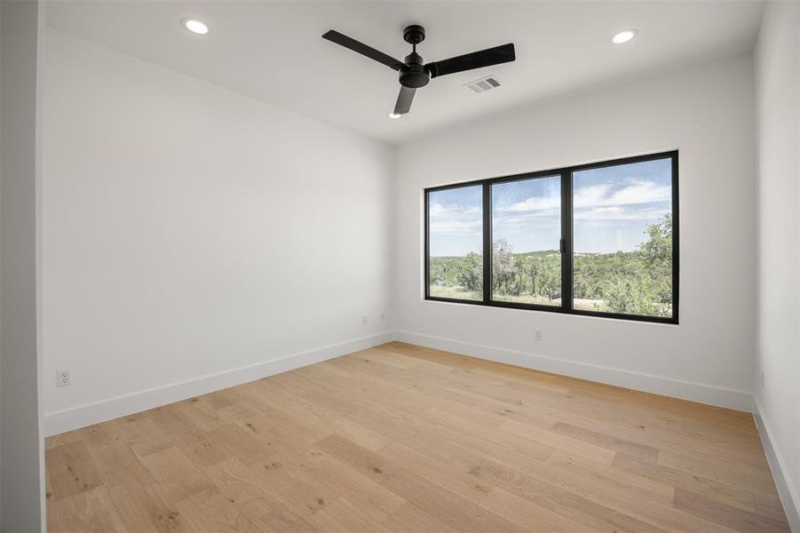 Bedroom # 4 with hardwood floors and a wide window with scenic views define this inviting room.