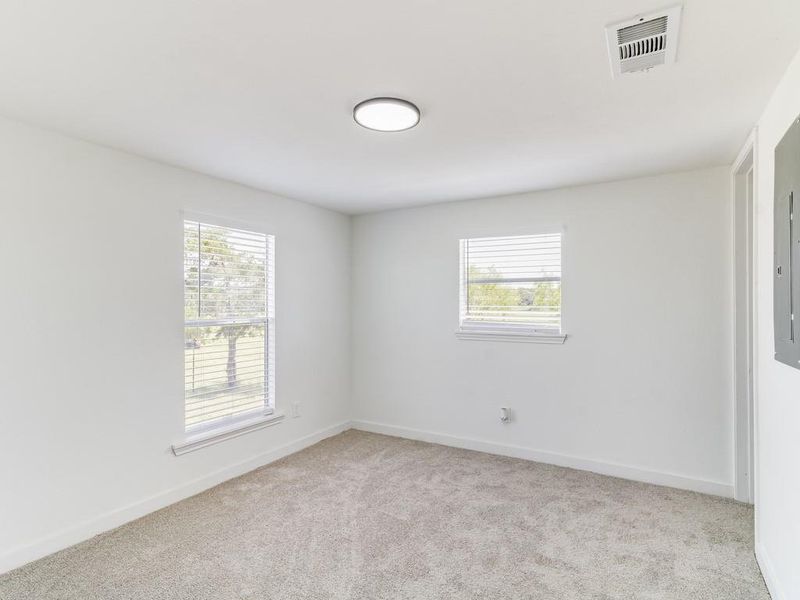 Empty room with carpet flooring and baseboards Empty room with carpet flooring and baseboards