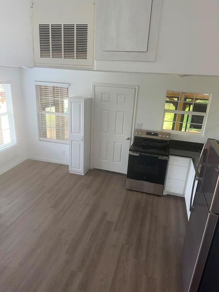 A well-lit kitchen with sleek appliances and practical flooring.