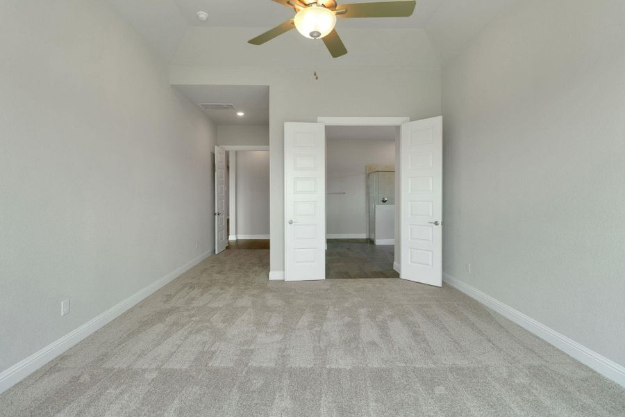 Unfurnished bedroom with a walk in closet, baseboards, carpet flooring, and visible vents