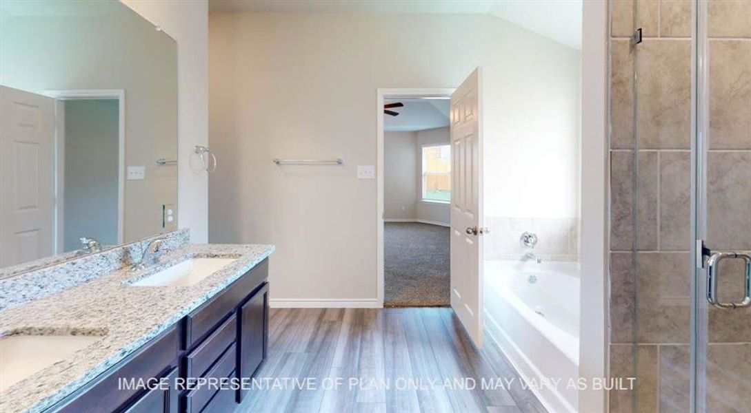 Bathroom featuring a bath, double vanity, a stall shower, light wood-style flooring, and lofted ceiling Bathroom featuring a bath, double vanity, a stall shower, light wood-style flooring, and lofted ceiling