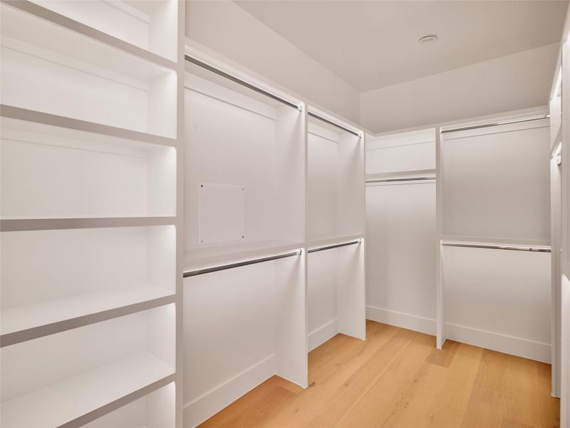 Walk in closet with light wood-style flooring