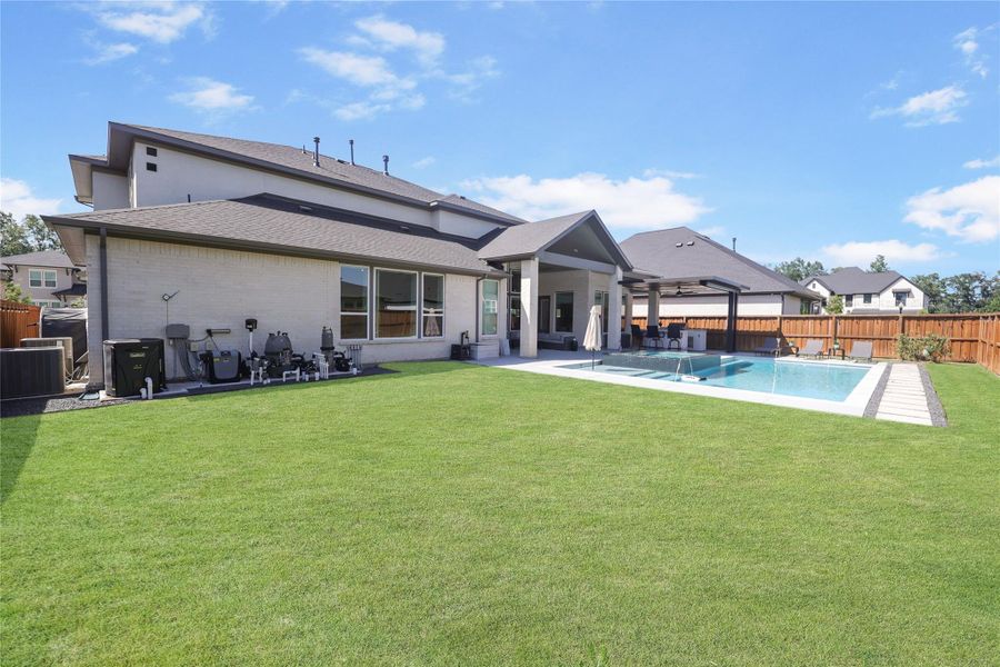 The oversized backyard offers plenty of green space for kids and pets to play, whether it's throwing a football, kicking a soccer ball, or enjoying a game of frisbee.