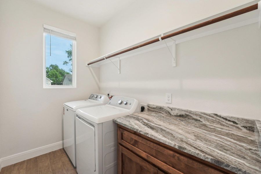 Laundry room with light wood-style flooring, baseboards, independent washer and dryer, and laundry area Laundry room with light wood-style flooring, baseboards, independent washer and dryer, and laundry area