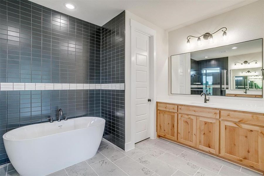 Bathroom with tile walls, tile flooring, and vanity