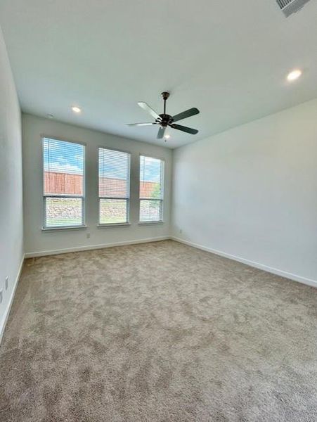 Room featuring three windows with blinds, a ceiling fan, recessed lighting, and neutral-toned carpeting