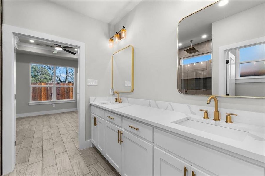 Bathroom with double vanity, a sink, and recessed lighting