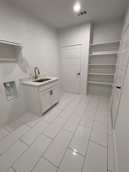 Utility room with sink and tile patterned floors