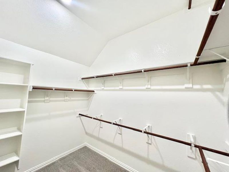 Walk in closet with carpet and lofted ceiling Walk in closet with carpet and lofted ceiling