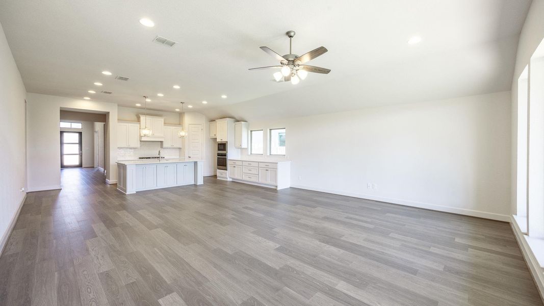 Unfurnished living room with recessed lighting, dark wood finished floors, ceiling fan, and vaulted ceiling Unfurnished living room with recessed lighting, dark wood finished floors, ceiling fan, and vaulted ceiling