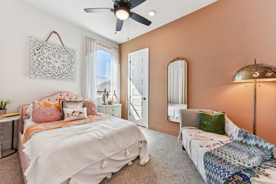 Plush carpeting and high ceilings define this inviting secondary bedroom setup.