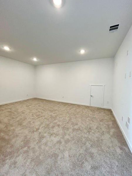 Spacious room with new carpeting, crisp white walls, recessed ceiling lighting, and a white interior door Spacious room with new carpeting, crisp white walls, recessed ceiling lighting, and a white interior door