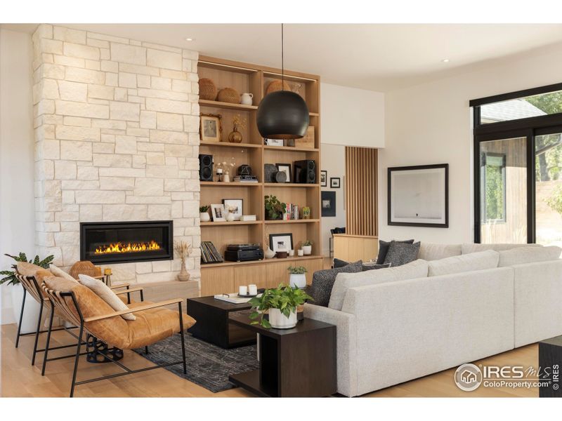 Wide-plank white oak floors and walls of glass blur the line between indoors and out, while a stone-surround fireplace with custom shelving anchors the great room. Wide-plank white oak floors and walls of glass blur the line between indoors and out, while a stone-surround fireplace with custom shelving anchors the great room.