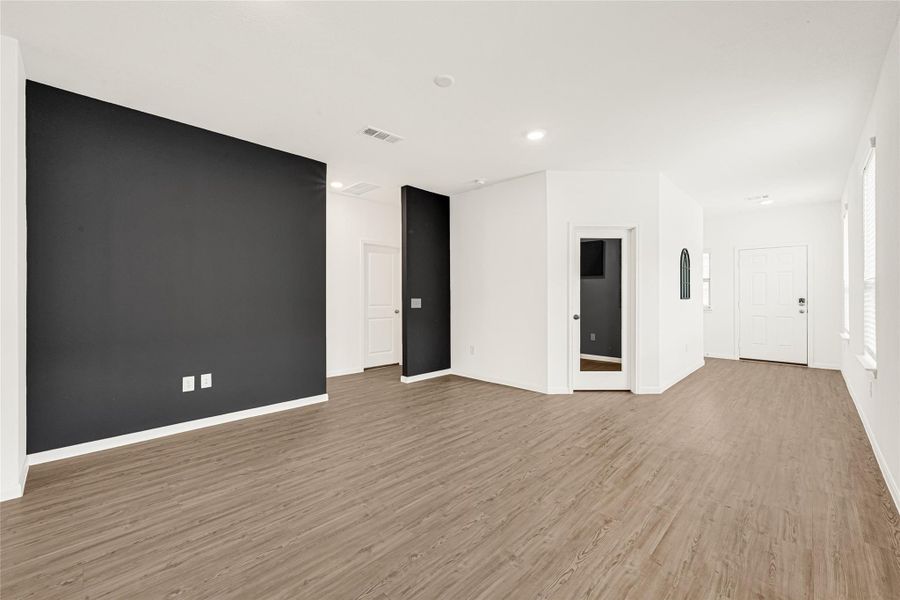 Open interior view looking toward a bold dark accent wall with clean, modern flooring lines.