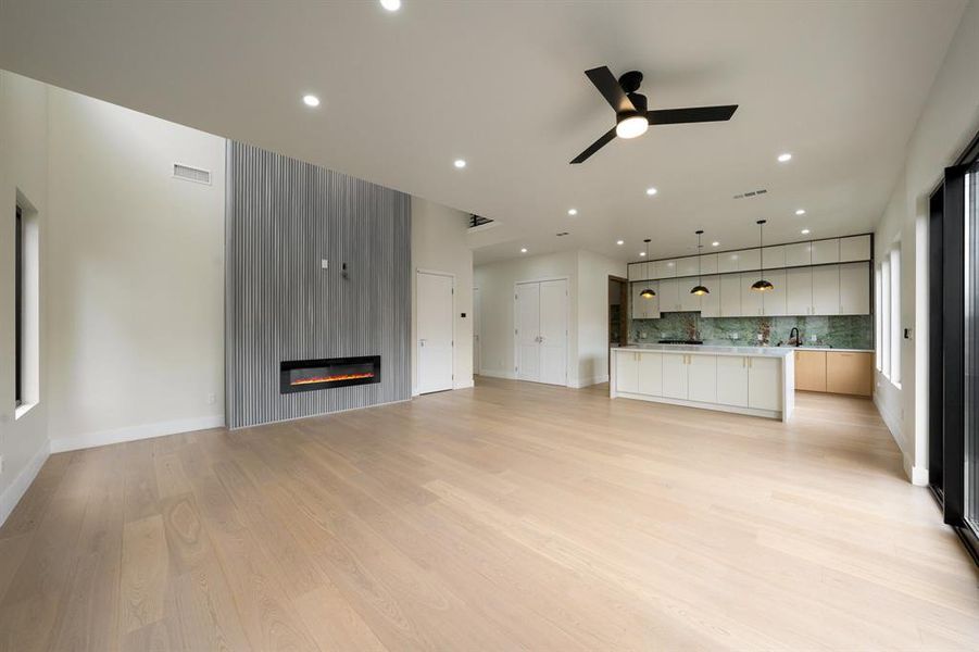 Family room featuring light wood-style floors, a fireplace, ceiling fan, and recessed lighting