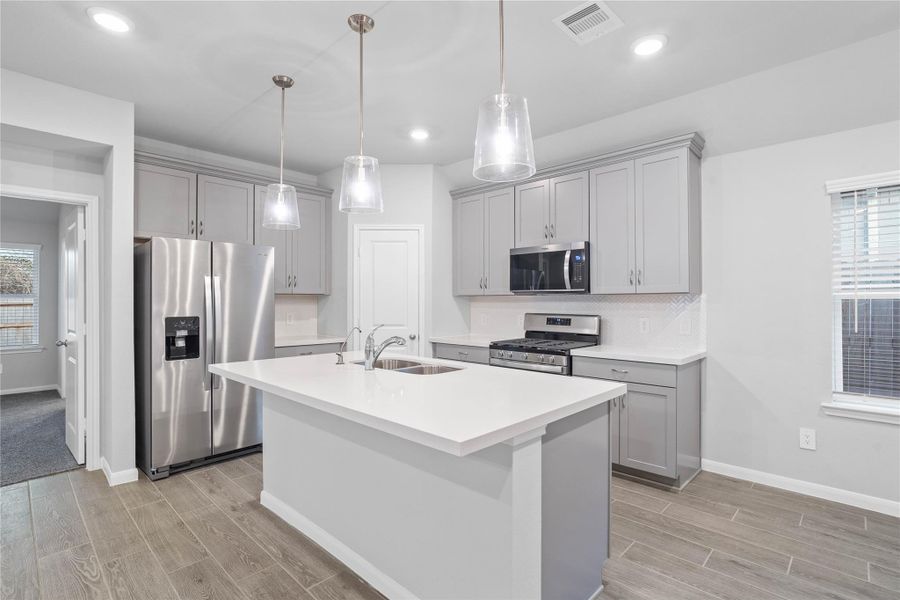 The expansive quartz-topped island stands as the home's true heartbeat, offering a natural gathering spot where family and friends naturally gravitate to share meals, conversation, and connection.