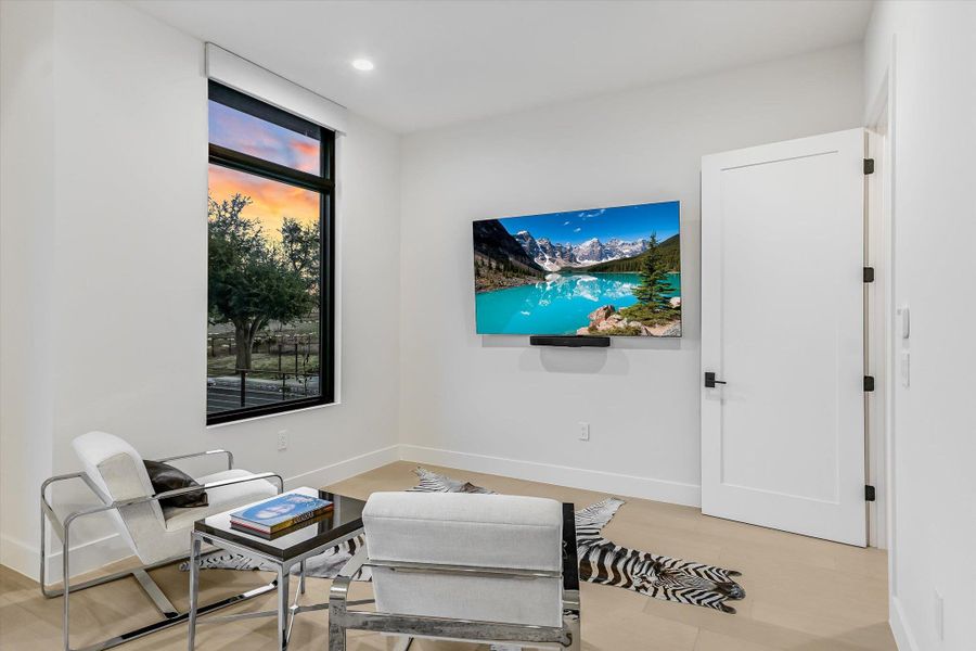 Living area with light wood-style flooring and recessed lighting Living area with light wood-style flooring and recessed lighting