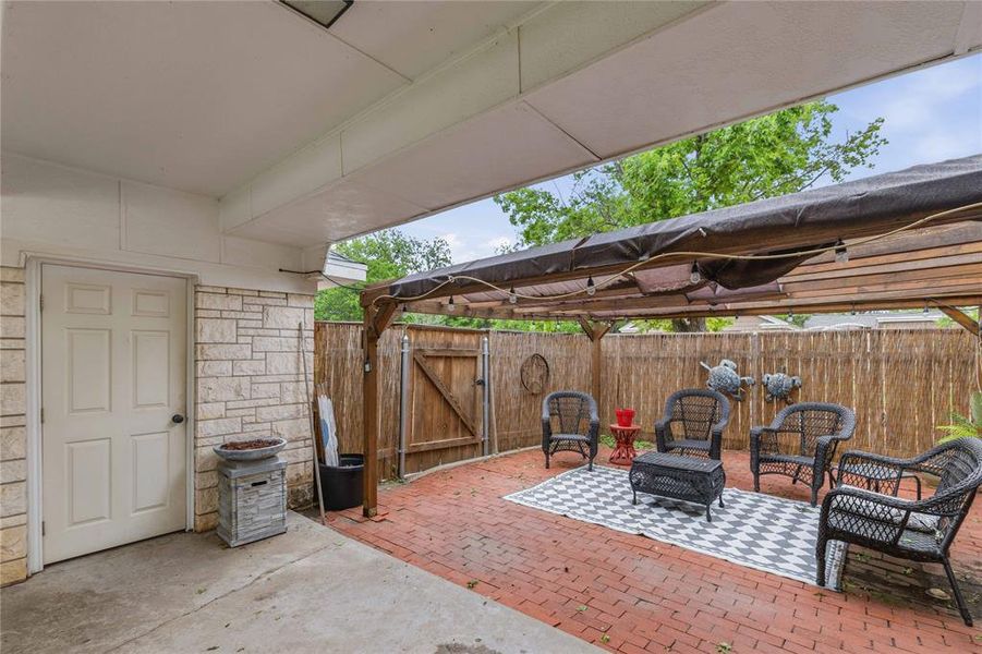 Covered patio featuring a solid roof, a privacy fence, and brick paver flooring Covered patio featuring a solid roof, a privacy fence, and brick paver flooring
