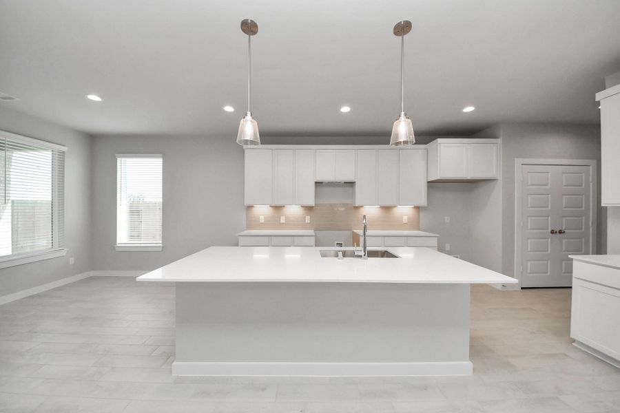 This kitchen is by far any chef’s dream! This spacious kitchen features high ceilings, light stained wood cabinets, granite countertop, SS appliances, modern tile backsplash, recessed lighting, extended counter space, granite kitchen island with double sink, and space for breakfast bar, and a walk-in pantry all overlooking your huge family room.