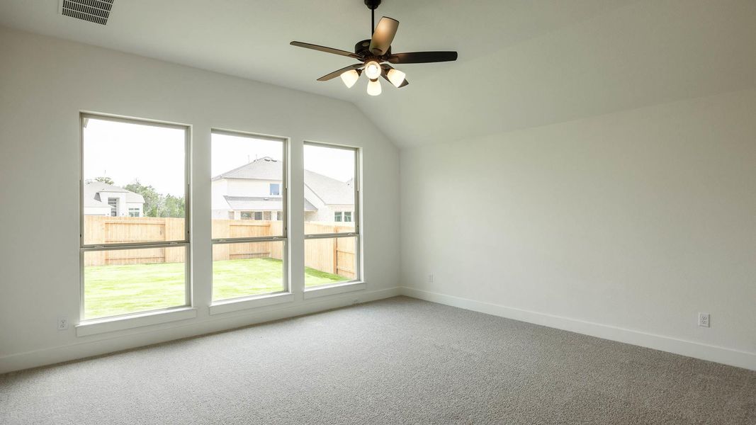 Additional living space featuring carpet floors, vaulted ceiling, baseboards, and ceiling fan