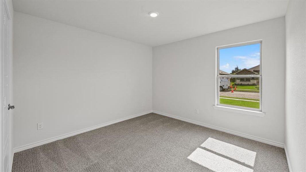 Neutral tone paint throughout, featuring a window with white trim, gray carpet flooring, white baseboards, and a recessed ceiling light Neutral tone paint throughout, featuring a window with white trim, gray carpet flooring, white baseboards, and a recessed ceiling light