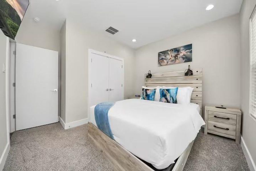 A comfortable secondary bedroom with enough space for a full bedroom setup while maintaining easy access to the nearby bath.