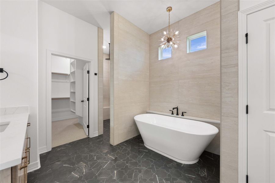 Luxurious bathroom retreat with a standalone soaking tub and spacious walk-in closet. Luxurious bathroom retreat with a standalone soaking tub and spacious walk-in closet.