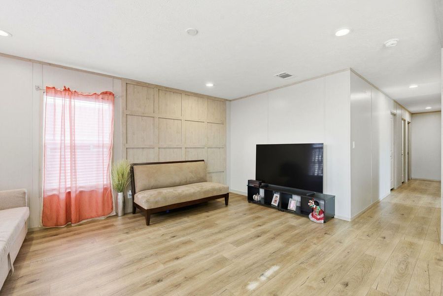 Sitting room with light wood-type flooring and recessed lighting