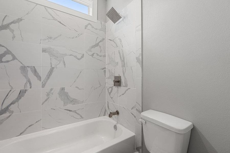 Full bathroom with shower / bath combination and a textured wall