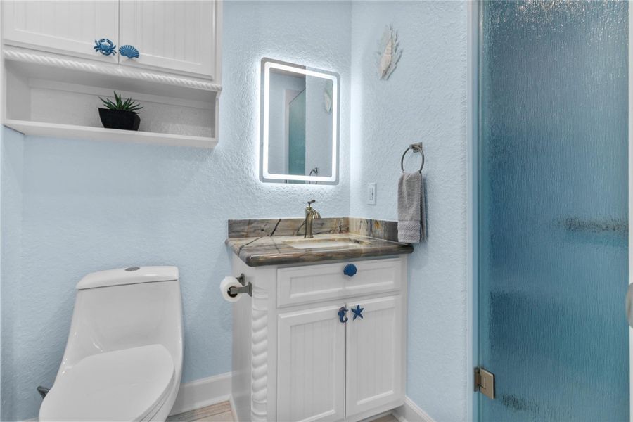 Luxury Brazilian Quartzite countertop and LED lighted mirrors in both bathrooms.