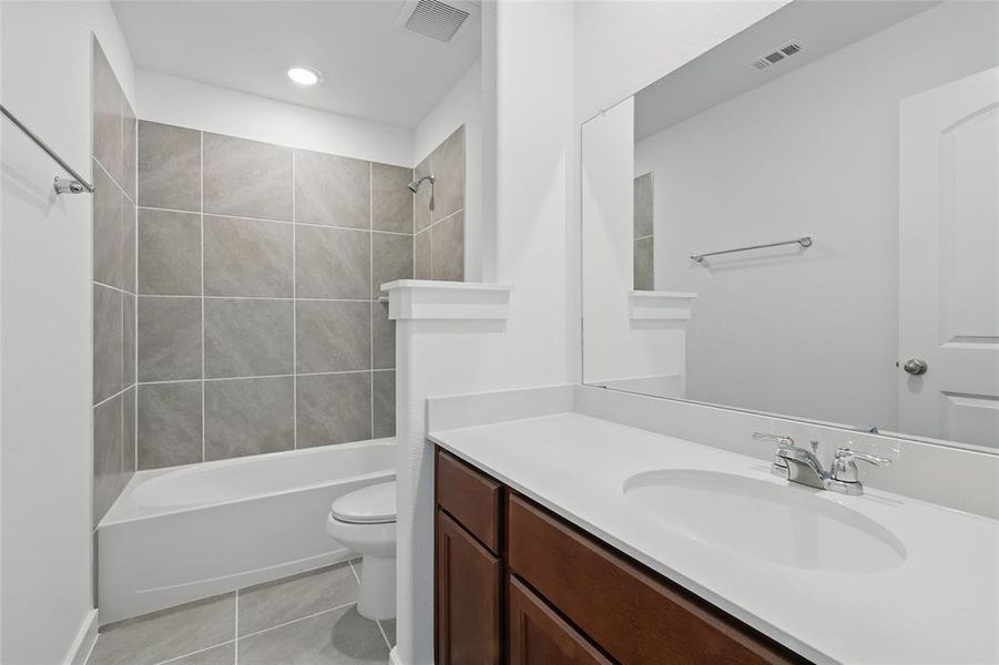 Full bath featuring vanity, light tile patterned floors, bathtub / shower combination, and recessed lighting Full bath featuring vanity, light tile patterned floors, bathtub / shower combination, and recessed lighting