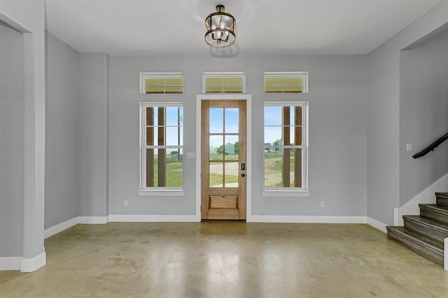 Entryway with concrete floors, baseboards, and stairs
