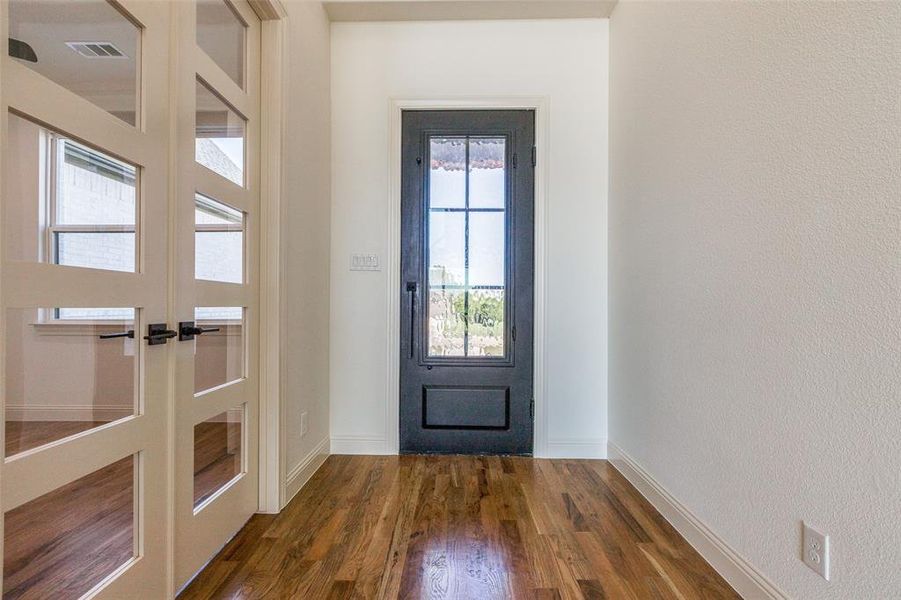 Doorway with french doors and dark hardwood / wood-style floors