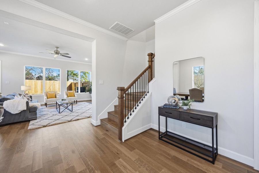 Elegant Transition: This beautifully crafted staircase, with warm wood tones and sleek iron balusters, leads to the versatile second floor featuring a game room and private office space—perfect for work and play.