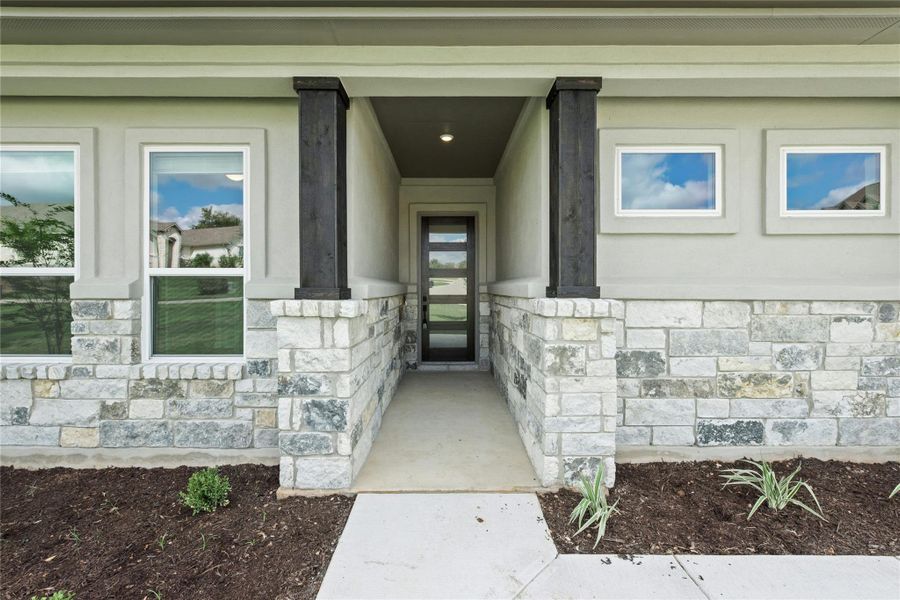 Doorway to property with stone siding and a porch Doorway to property with stone siding and a porch