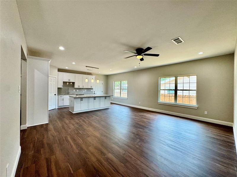 Unfurnished living room featuring dark hardwood / wood-style floors and ceiling fan