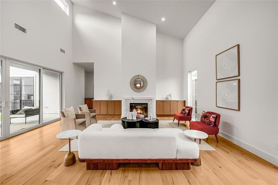 Living area featuring vaulted ceilings, a fireplace with a stone surround, and wood-finish flooring