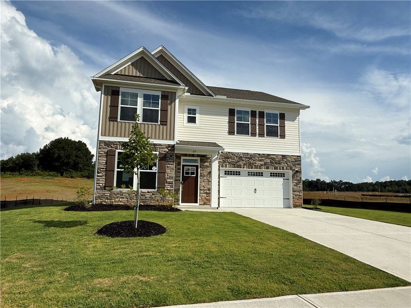 A well-maintained facade features mixed siding, st A well-maintained facade features mixed siding, st