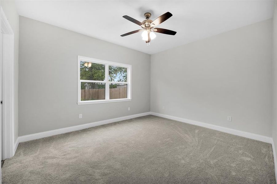 Carpeted spare room featuring baseboards and a ceiling fan Carpeted spare room featuring baseboards and a ceiling fan