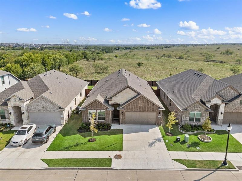 Aerial view showcasing the home’s prime location with no neighbors directly behind, offering added privacy and expansive greenbelt views.