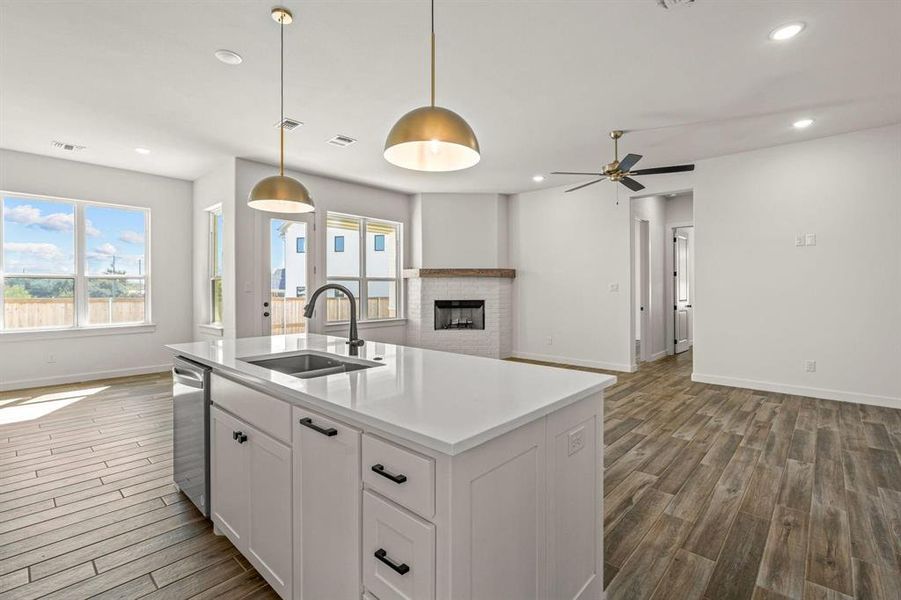 Kitchen with a sink, open floor plan, baseboards, recessed lighting, and dark wood-style flooring